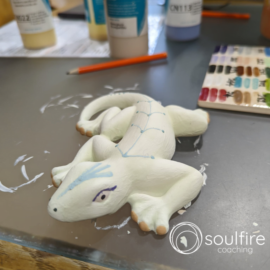 A pottery lizard in the process of being painted: play and success